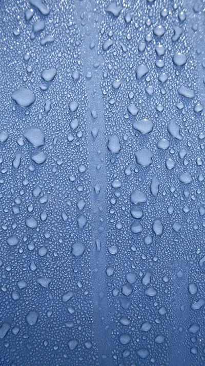 Water drops on a polished blue motorhood