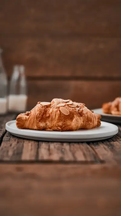 Almond croissant with custard filling on wood background - Screenshot 1