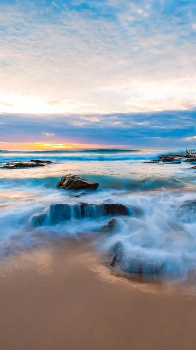 Flowing water over rocks on the beach shore