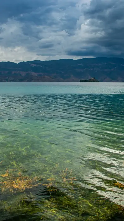 The crystal clear lake water reflects the blue sky