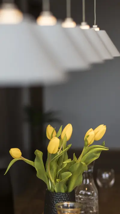 Yellow dandelions in a vase and an open book on the table