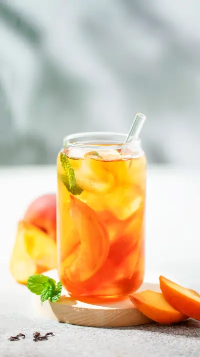 Fruit iced tea with peaches in a glass on the table - Screenshot 1