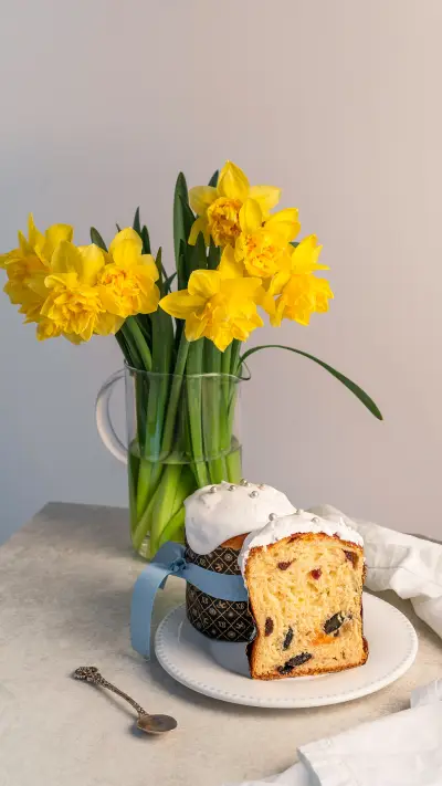 Cake with dried fruits, cut in half, on white plate