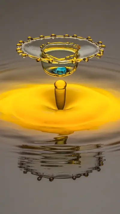 Yellow water drop forming crown with light blue dot in