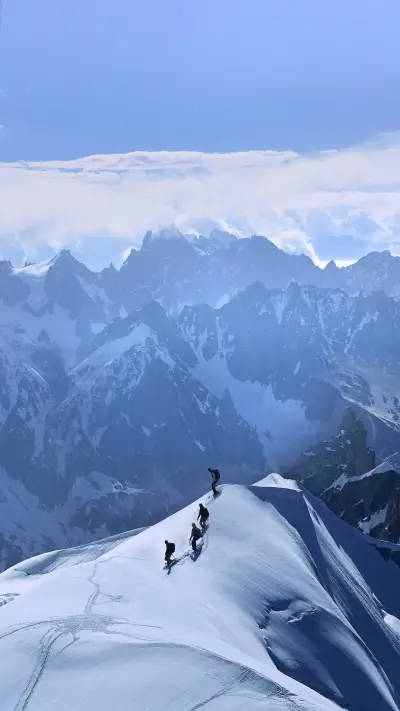 A Group of People Are Climbing The Snow Mountain