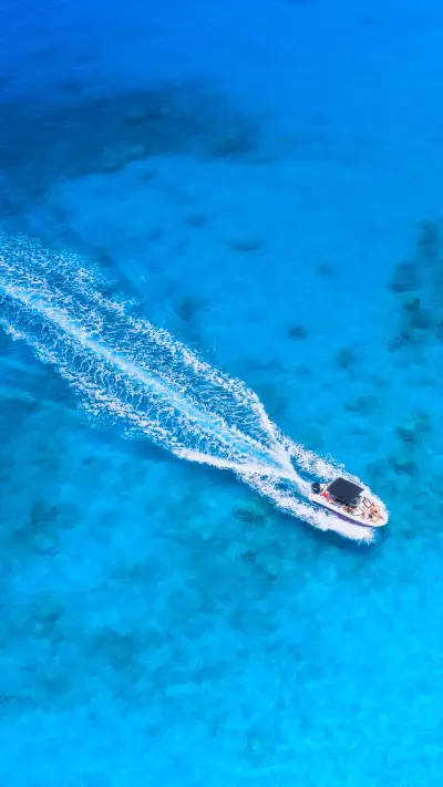 Aerial view of the speed boat in clear blue water at sunset