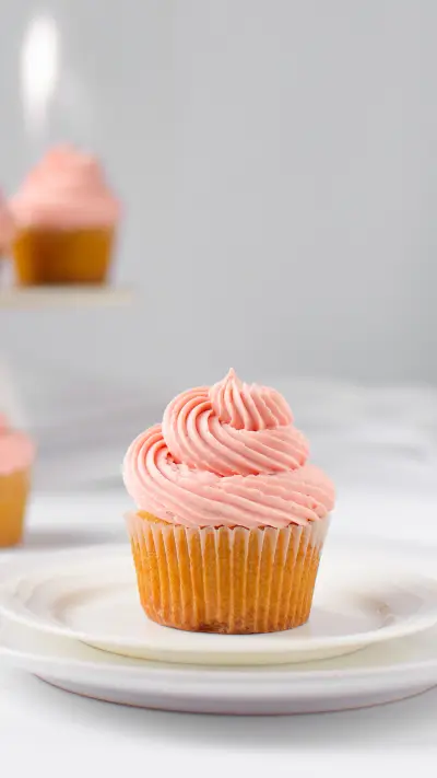 Vanilla cupcake with pink buttercream on a plate