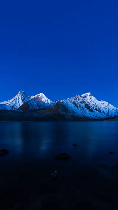 The snow capped mountains in the evening