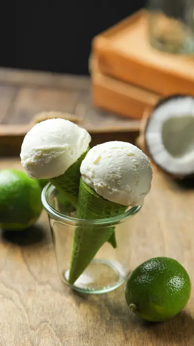 Ice cream balls in a waffle green cone with coconut